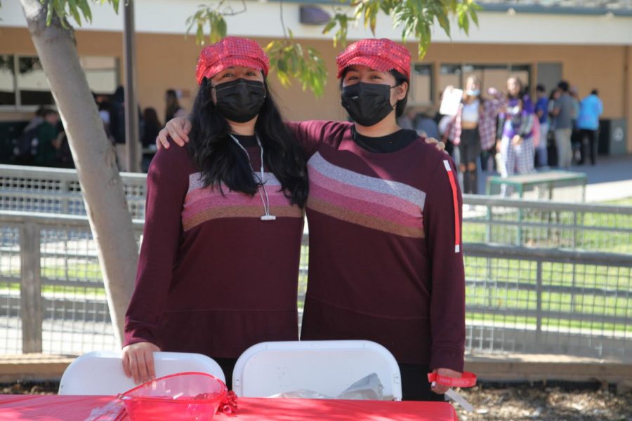 Seniors Brenda and Brissa Sanchez stand outside during lunch to pass out wristbands to students pledging to be drug free