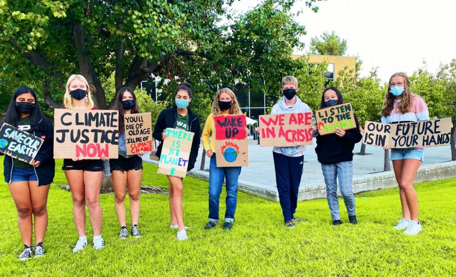 The group of 8 student protestors (Raina Agrawal, Katie Gavigan, Shani Edelstein, Ella Garcia, Megan Juza, [random kid], Ellie Russo, and Mackenzie Juza) stand together holding their signs, in an effort to fight against climate change before school starts.