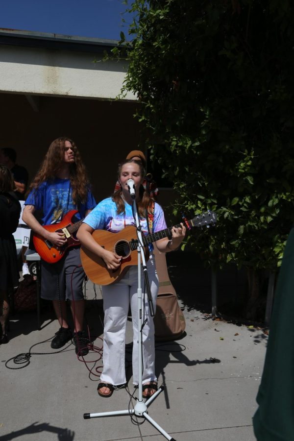 Sophomore Hannah Roby plays live music in the main hallway to promote her songwriting club. Roby  wrote and produced her own song last year and wants to meet fellow Titans to create music together. 