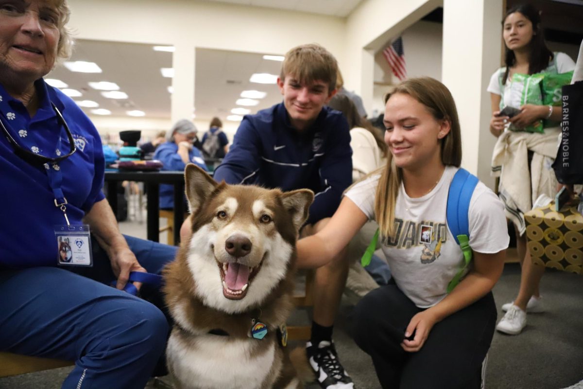 Relieving+some+stress%2C+seniors+Colin+Finney+and+Landee+McIntosh+spend+time+with+a+therapy+dog.+Starting+this+year%2C+a+group+of+therapy+dogs+are+visiting+the+PHS+library+monthly.%0A