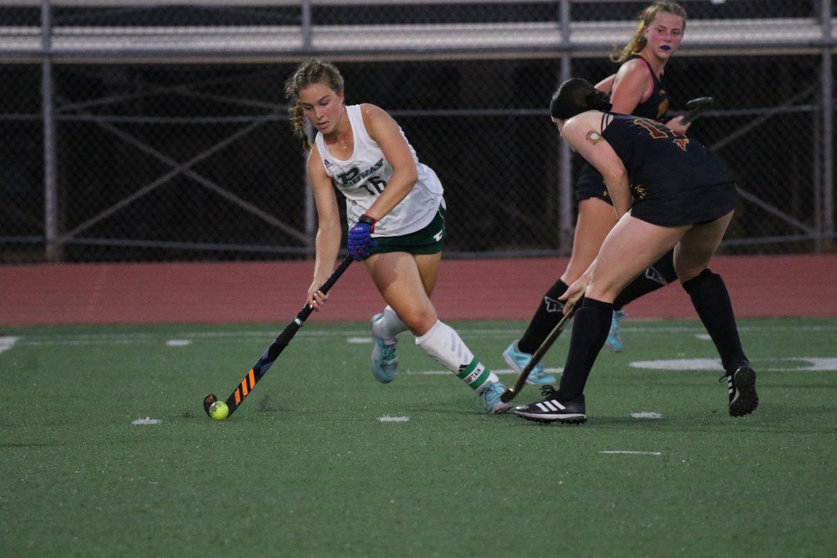 Preparing to make a pass, senior Anjolie Norton carefully handles the ball. Norton is a co-captain and leads the team with 16 goals this season.