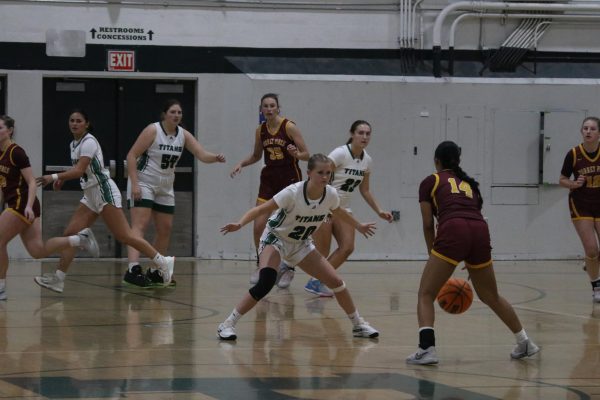 Senior Allie Hawkins defends the basket from her Torrey Pines opponent backed by the rest of her team. The Titans started off their season with eight wins and two losses. 