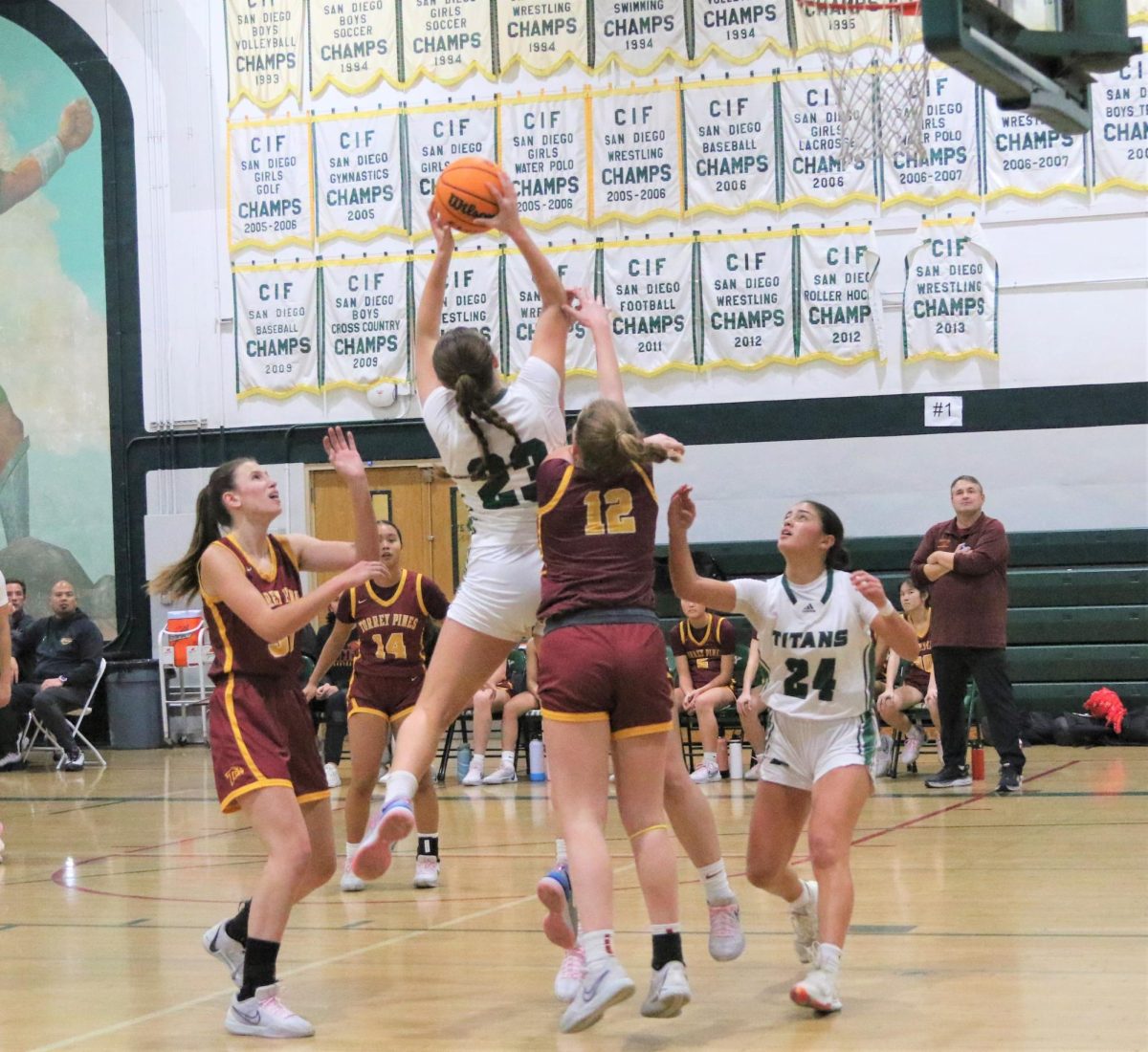 Going for the basket: Junior Katelyn Johnson leaps to put the ball through the hoop, during a home game against Torrey Pines Dec. 12, as her senior teammate Teya White waits to catch a potential rebound.