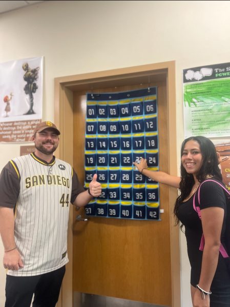 Senior Amanda Flores puts away her phone in  Law and Action teacher Noah Lapp’s phone jail before class.
