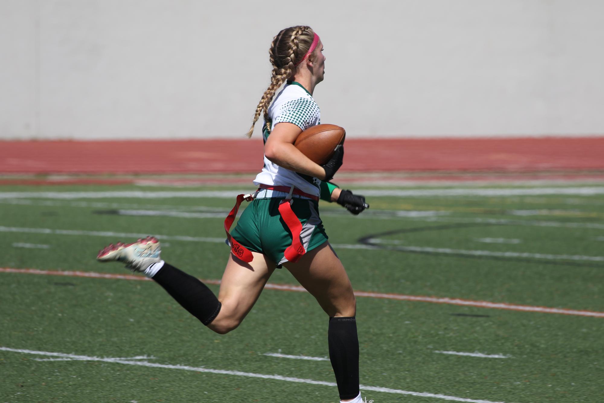 Speeding ahead of her opponents, sophomore Delaney Hughes runs toward the endzone to make a touchdown.