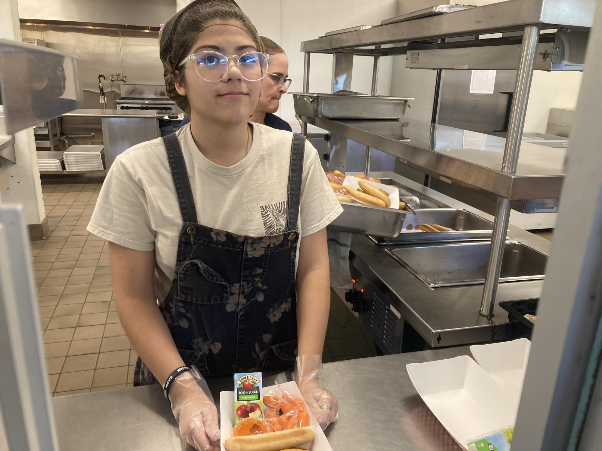 Hard at work:  Junior Nevaeh Brown serves food to classmates in the cafeteria at lunch. 