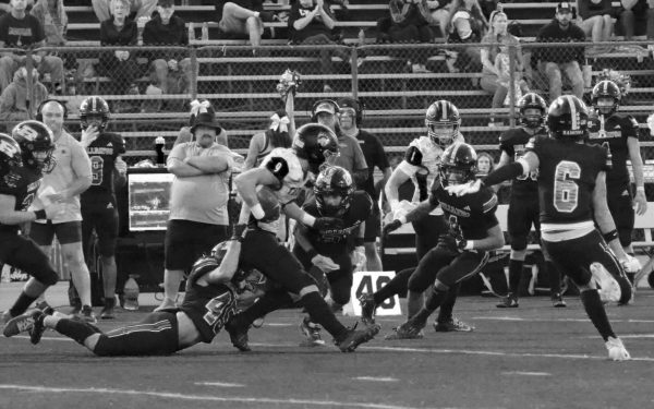 Pushing ahead: Junior Luke Jorgensen runs to the end zone to try and score a touch down while having a Ramona High player pulling him down. 