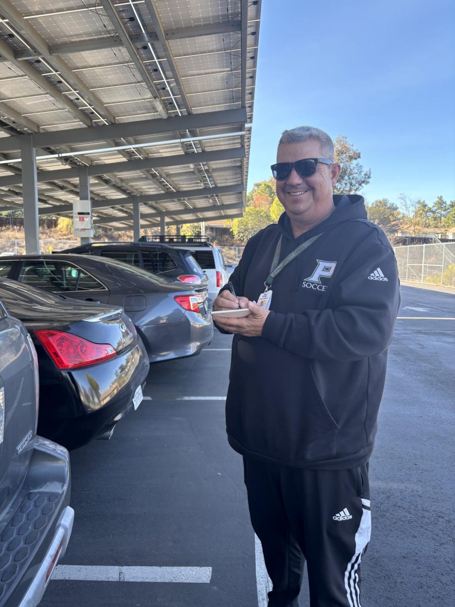 Ticketing takes a turn: Campus supervisor Gene Morris in the senior
lot with his parking ticket booklet.