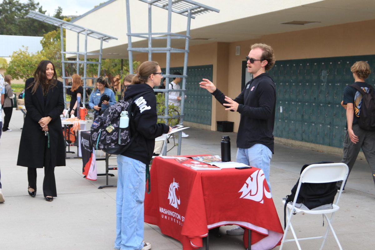 Freshman Audrey Bunje was  interested in what the Washington State booth had to say. The representative answers her questions  about the university.
