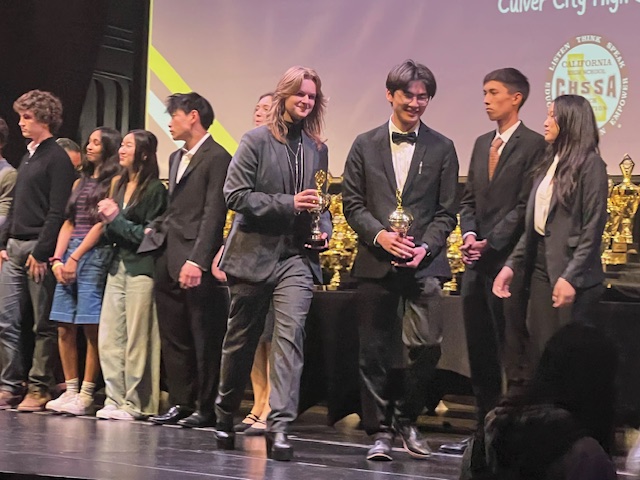 Walking with pride: Power duo junior Hannah Jones and senior Sherwood Kao smile greatly receiving trophies. Placing 11th out of 64 teams Jones and Kao hard work has payed off.