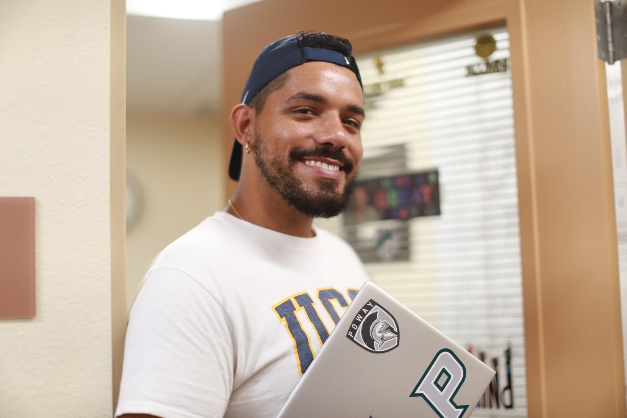 Assistant Principal Dominick Spylios smiles outside of his new office in a welcoming manner, proudly representing Titan pride.