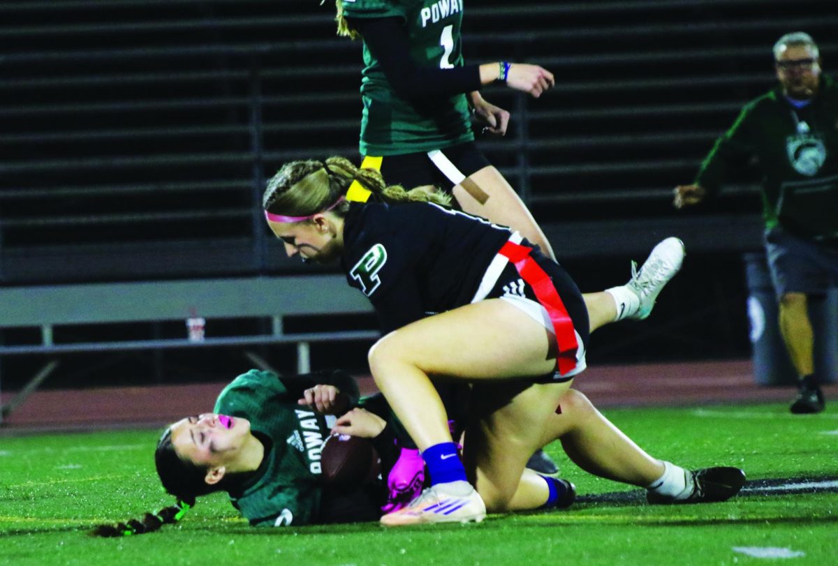 Senior Scarlett Simon hunches
over junior opponent Dylan Nicholas after she fell to the ground when
Simon pulled her flag.