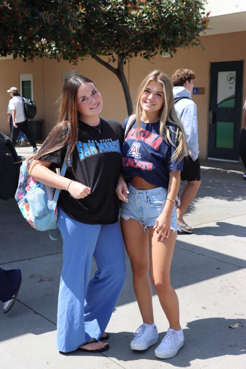 Seniors Olivia Dunnick and Kylie Yenor pose together, repping their college on their t-shirts.